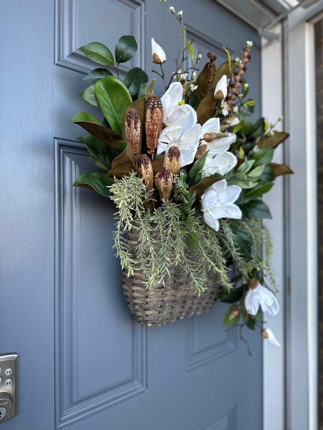Basket for front door with magnolia florals and greenery with natural branches and pods 24"x21"x5. Matches wreath!!!