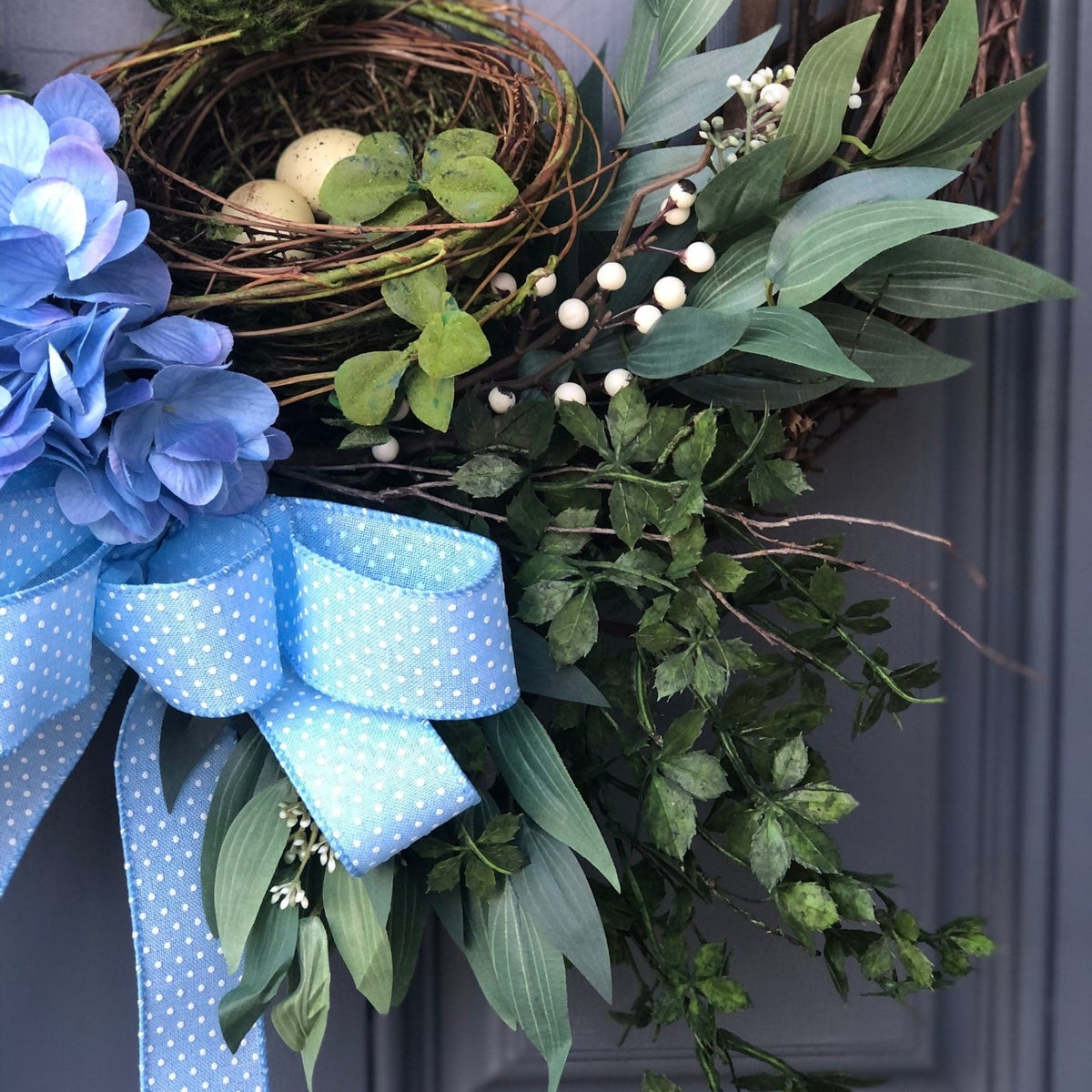 CLose up of nests and bow on Blue hydrangea front door wreath