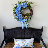 Blue hydrangea front door wreath displayed over a bench