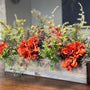 This fall centerpiece is perfect for decorating your table top! It is a grey wash wooden rectangle box 20&quot; long x 9&quot; high by 5&quot; This rustic style arrangement is stunning with orange hydrangeas nestled in greenery with acorns, pinecones and berries