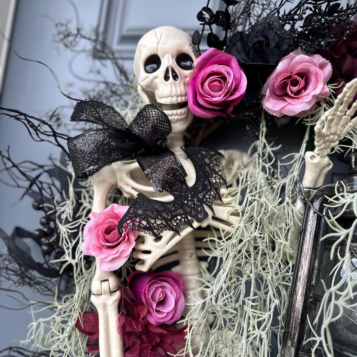 Halloween skeleton door wreath with a lantern that lights up, Moveable 36" skeleton holds light and is nestled in creepy moss and pink roses