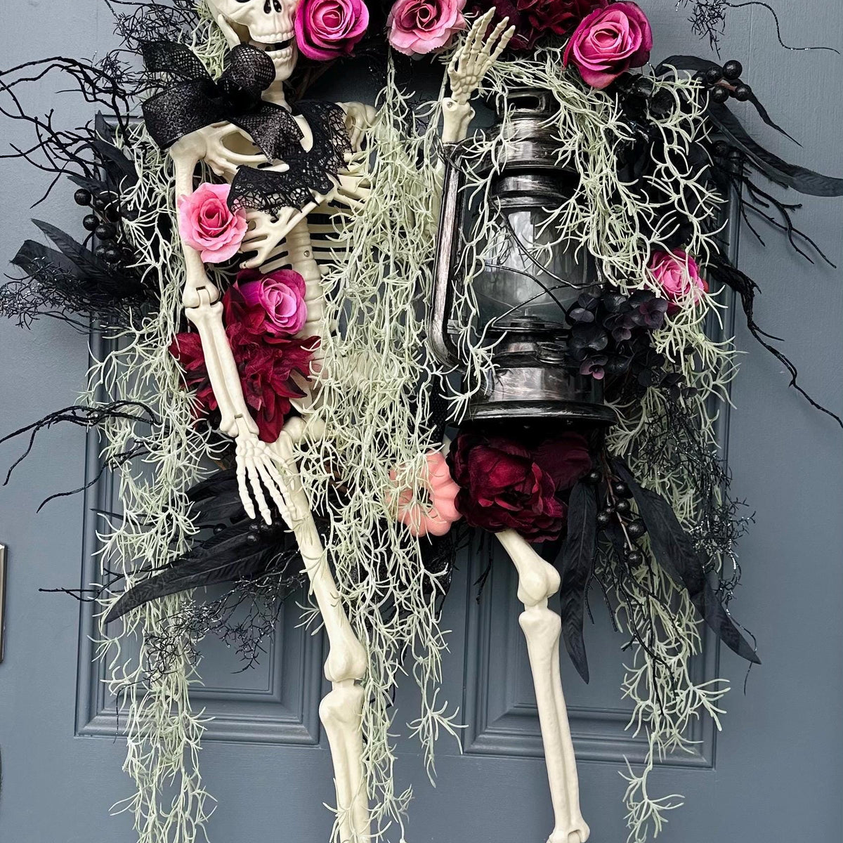 Halloween skeleton door wreath with a lantern that lights up, Moveable 36" skeleton holds light and is nestled in creepy moss and pink roses