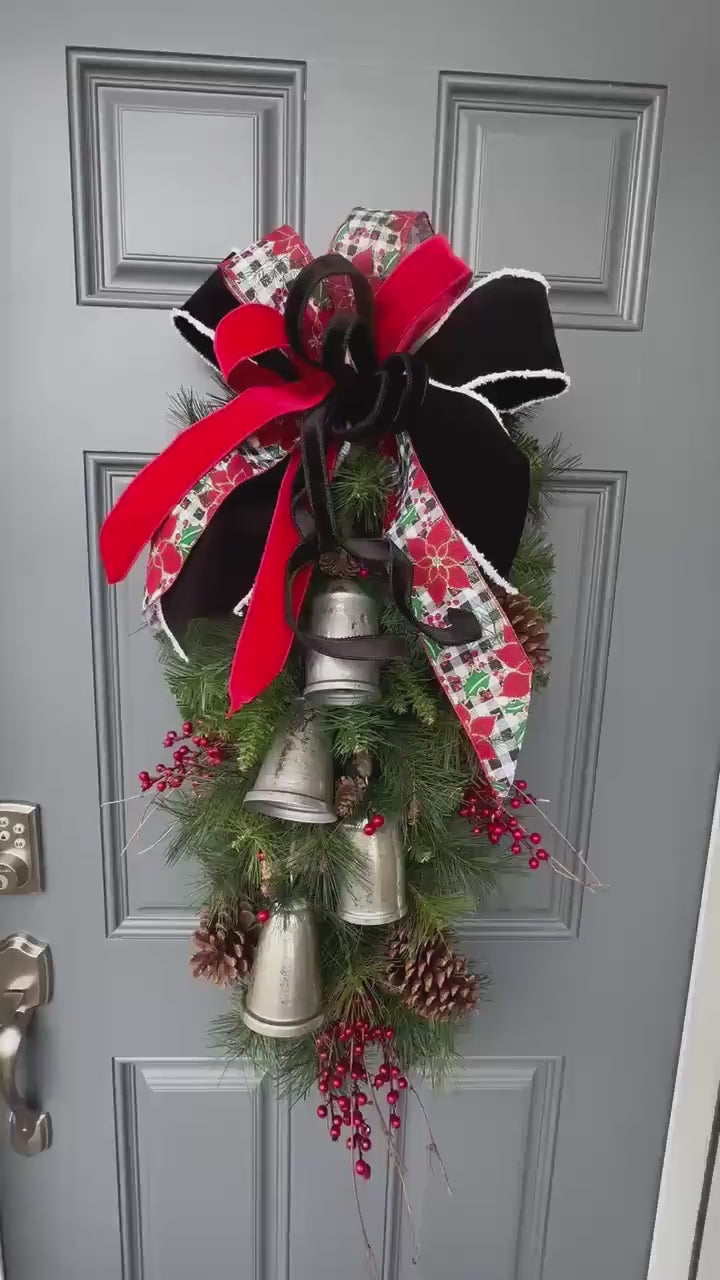 Christmas front door swag with Silver metal bells. Mixed pine with natural pinecones and red berries with twigs topped with a stunning bow!