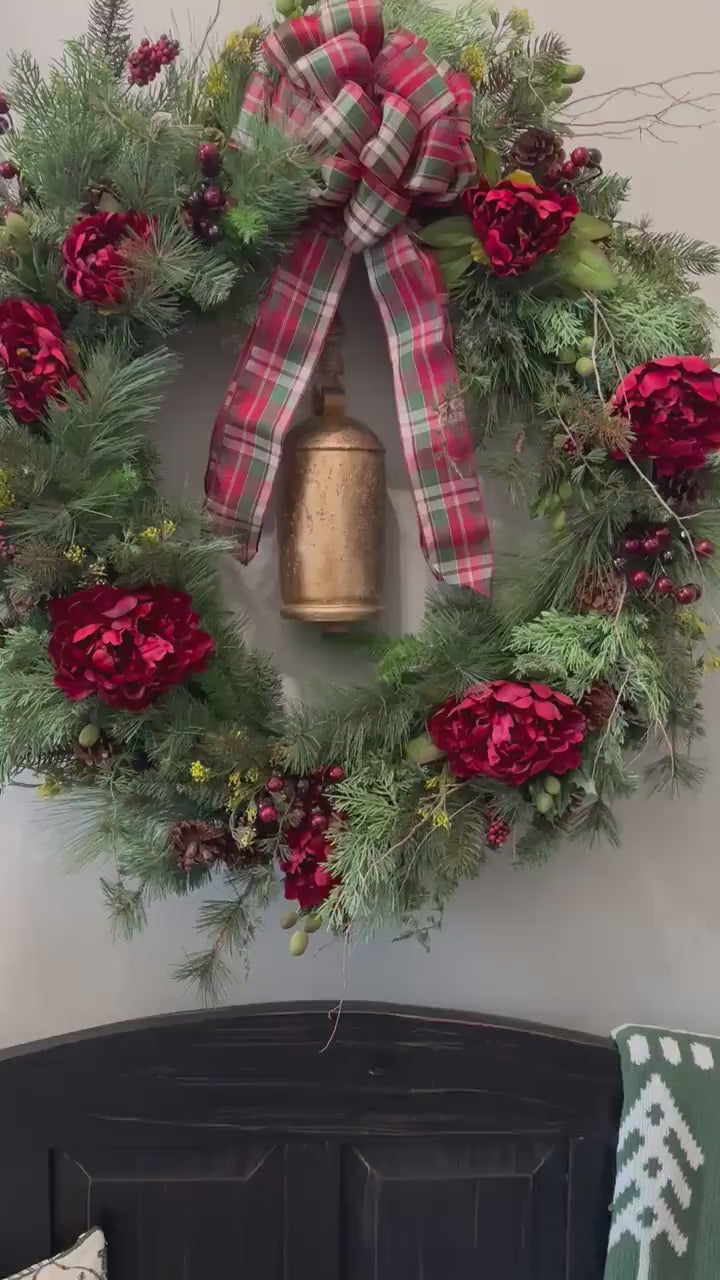 Rustic woodland Christmas wreath with natural elements, pines, juniper topped with a plaid bow and brass bell perfect for farmhouse decor.