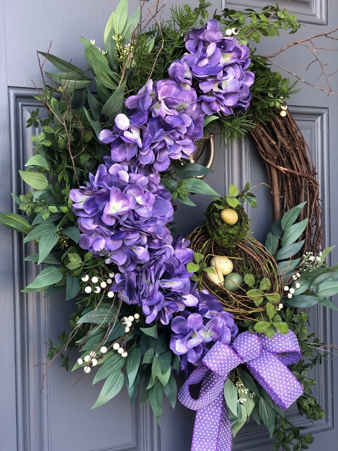 Purple spring front door wreath, purple hydrangeas, a bird nest with eggs