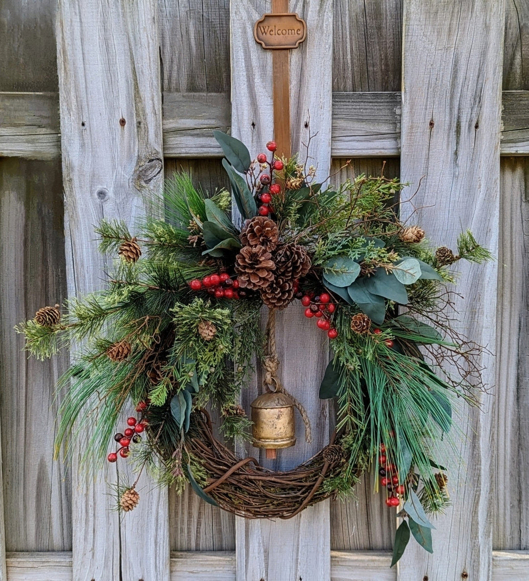 Rustic holiday winter wreath with brass bell. Faux natural wreath for entire season. Available with Red or Blue Berries.